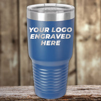 A blue Kodiak Coolers Custom Tumbler with a clear lid features "YOUR LOGO ENGRAVED HERE" in white. Engrave your logo or design—no setup fees and a $200 minimal order—ideal for promotional gifts.