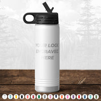 A Kodiak Coolers custom white water bottle with an engraved logo sitting on a wooden table.