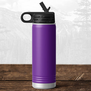 A Kodiak Coolers 20 oz water bottle with flip top straw, laser engraved for Wisconsin Green Bay Bulldogs fans, rests on wood; this school drinkware is perfect for Bulldog supporters and stands out against a blurred mountain backdrop.