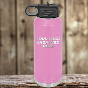 A pink Kodiak Coolers insulated bottle with "YOUR LOGO ENGRAVED HERE" on the front, black lid, and wood background—great as a promotional gift. 4th of July SALE: Custom logo drinkware, $200 minimum order.