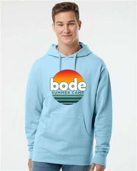 Someone in a Printify 2026 Bode Summer Bootcamp OG Logo Hoodie Sweatshirt (Unisex Independent Trading Co. SS4500) in light blue, featuring a cotton-poly fleece, adjustable hood, and sunset "bode summer camp" graphic on the front.