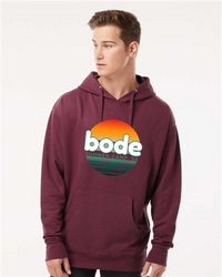 A person wears the Printify 2026 Bode Summer Bootcamp OG Logo Hoodie (Unisex Independent Trading Co. SS4500) in maroon, featuring a sunset graphic and an adjustable cotton-poly fleece hood for comfort and style.