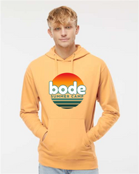 A person wears the unisex Printify 2026 Bode Summer Bootcamp — OG Logo Hoodie Sweatshirt (Independent Trading Co. SS4500) featuring a sunset graphic and logo, in yellow cotton-poly fleece, against a plain white background.