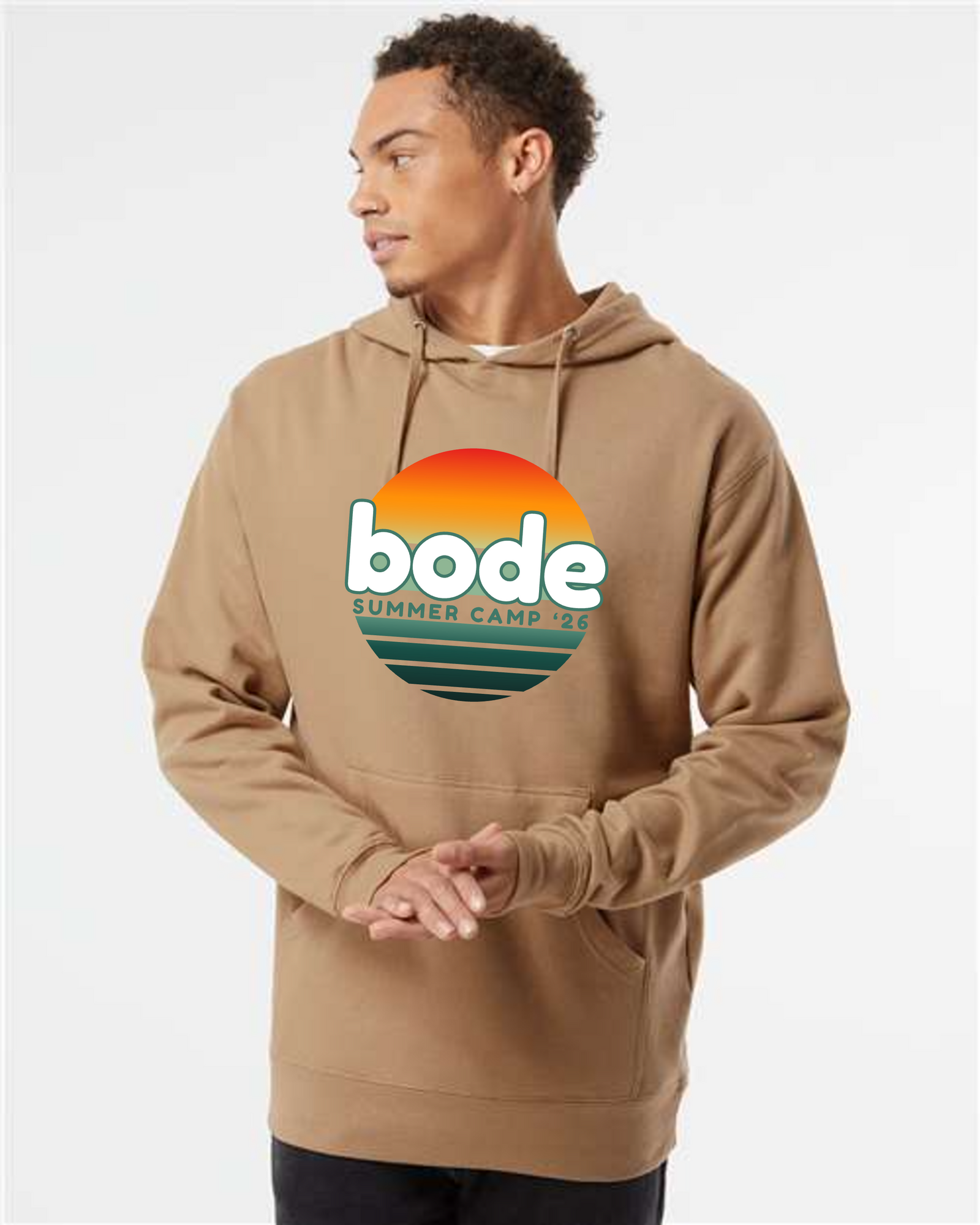 Someone wears a tan Printify 2026 Bode Summer Bootcamp — OG Logo Hoodie Sweatshirt (Unisex Independent Trading Co. SS4500), featuring a colorful logo on the front, and looks to the side against a plain background.