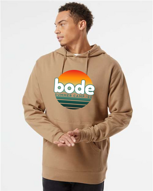 Someone wears a tan Printify 2026 Bode Summer Bootcamp — OG Logo Hoodie Sweatshirt (Unisex Independent Trading Co. SS4500), featuring a colorful logo on the front, and looks to the side against a plain background.