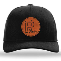 The designerapp Pulaski Reds Baseball Richardson 112 Snapback Trucker Cap features a black trucker style with a custom brown leather patch: a circular "P" and "Reds" logo embroidered below.