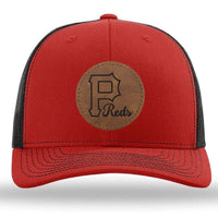 The designerapp Pulaski Reds Baseball Richardson 112 snapback trucker cap features a custom leather patch with the large "P Reds" logo on a red and black hat.