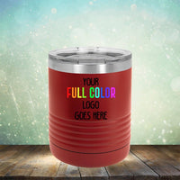 A red insulated tumbler on a wooden surface with the text "Your Full Color Logo Goes Here" on it, set against a blurred background with bokeh lights, perfect for anyone seeking Custom UV Printed Drinkware - Single Side Printing Included in Price from Kodiak Coolers.