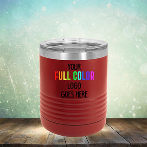 Red insulated tumbler with a metal lid and "Your Full Color Logo Goes Here" text displayed on the front, set on a wooden surface against a sparkly background. Perfect for engraving, this versatile piece complements any collection of Kodiak Coolers Custom UV Printed Drinkware - ONE TIME SPECIAL OFFER tumblers or coffee mugs.