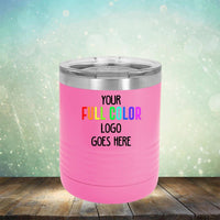 A pink insulated tumbler with a metal lid sits on a wooden surface. The tumbler has text that reads "Your Full Color Logo Goes Here." Perfect for promotional events, these customized Custom UV Printed Drinkware - Single Side Printing Included in Price by Kodiak Coolers feature a light bokeh effect in the background.