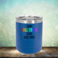 A blue Custom UV Printed Drinkware - Single Side Printing Included in Price with a stainless steel lid by Kodiak Coolers is placed on a wooden surface against a blurred bokeh background. The customized drinkware has text that reads "Your Full Color Logo Goes Here".