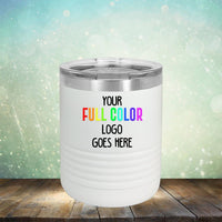 White insulated tumbler with text "YOUR FULL COLOR LOGO GOES HERE" on a wooden surface against a sparkling green and blue background. Perfect for promoting your brand, these Custom UV Printed Drinkware - Single Side Printing Included in Price by Kodiak Coolers are ideal for keeping beverages at the right temperature.