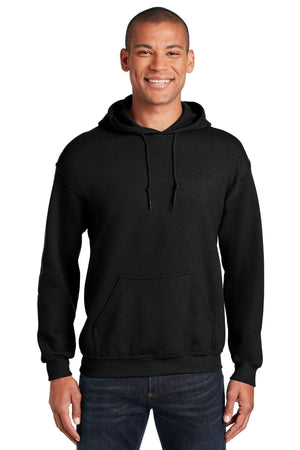 A person is standing and smiling, wearing blue jeans and a Gildan Heavy Blend™ Hooded Sweatshirt 18500 (Pack of 36) with custom screen printed logo, against a white background.