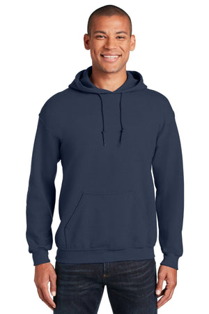 A man faces the camera, smiling, wearing a Gildan Heavy Blend Hoodie Sweatshirt 18500 in navy blue with dark jeans, set against a white background.