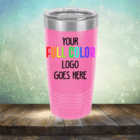 A pink tumbler with a silver lid is displayed on a wooden surface with a blurred, colorful background. The **Kodiak Coolers Custom UV Printed Drinkware - Single Side Printing Included in Price** has text stating, "Your full color logo goes here.