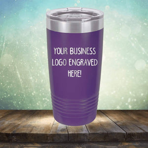 Purple Kodiak Coolers Custom Logo 20 oz Tumblers - SPECIAL OFFER - Front side Logo Included with the text "YOUR BUSINESS LOGO ENGRAVED HERE!" against a background with blurred lights, placed on a wooden surface. Perfect as a promotional gift, this personalized drinkware is ideal for showcasing custom logo mugs that leave a memorable impression.