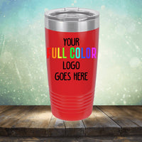 A red insulated tumbler with the text "Your Full Color Logo Goes Here" against a blurred light green and blue background, placed on a wooden surface. Perfect for those seeking customized tumblers that elevate their brand, the *Kodiak Coolers Custom UV Printed Drinkware - Single Side Printing Included in Price*.