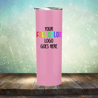 A pink Custom UV Printed Drinkware - ONE TIME SPECIAL OFFER by Kodiak Coolers with the text "YOUR FULL COLOR LOGO GOES HERE" engraved on it, placed on a wooden surface against a blurry background.