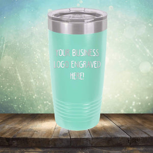 A turquoise Custom Logo 20 oz Tumbler - SPECIAL OFFER - Front side Logo Included c with a metallic lid on a wooden surface, featuring the text "Your business logo engraved here!" against a green gradient background. This piece of personalized drinkware by Kodiak Coolers makes an excellent promotional gift for your brand.