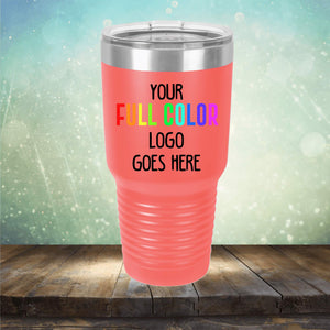 A red insulated tumbler with a silver lid is displayed on a wooden surface. The tumbler features the text "Your Full Color Logo Goes Here" in a bold, colorful font. Perfect for personalized engraving, the Custom UV Printed Drinkware - ONE TIME SPECIAL OFFER by Kodiak Coolers stands out against a light, sparkling gradient background.