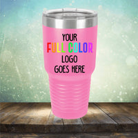 Pink Kodiak Coolers Custom UV Printed Drinkware with a stainless steel rim, featuring the text "YOUR FULL COLOR LOGO GOES HERE" against a blurred, light-filled background. Perfect for personalized coffee mugs, the tumbler rests elegantly on a wooden surface.