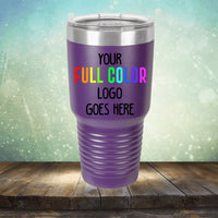 A purple insulated tumbler with a silver lid sits on a wooden surface, showcasing the text "Custom UV Printed Drinkware - Single Side Printing Included in Price." Ideal for those looking for customized tumblers from Kodiak Coolers, the background features a serene gradient of light greens and blues with a charming bokeh effect.
