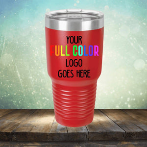 A red Custom UV Printed Drinkware - ONE TIME SPECIAL OFFER with the text "Your Full Color Logo Goes Here" against a bokeh background, placed on a wooden surface, perfect for showcasing personalized engravings by Kodiak Coolers.