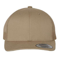 The YP Classics Yupoong Classics Six-Panel Retro Trucker Snapback Hat 6606 features a beige cap with a camo mesh back and flat brim, complete with a "Snapback" sticker on the front.