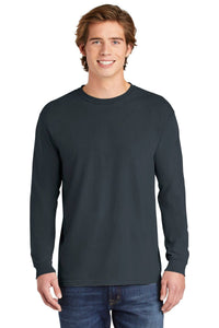 A young man smiles at the camera, wearing a Comfort Colors Heavyweight Ring Spun Long Sleeve T-Shirt 6014 in dark gray and blue jeans, standing against a white background.