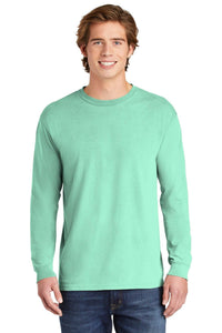 A young man with brown hair wears a Comfort Colors Heavyweight Ring Spun Long Sleeve T-Shirt 6014 in light green and blue jeans, standing against a white background.
