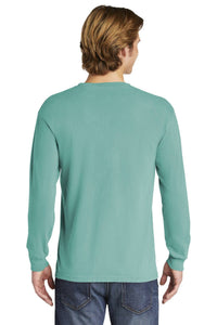 A person with light brown hair is shown from the back, wearing a teal Comfort Colors Heavyweight Ring Spun Long Sleeve T-Shirt 6014 and blue jeans against a plain background.