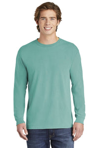 A young man stands facing forward against a white background, wearing blue jeans and a Comfort Colors Heavyweight Ring Spun Long Sleeve T-Shirt 6014 by Comfort Colors in teal.