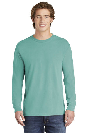 A young man stands facing forward against a white background, wearing blue jeans and a Comfort Colors Heavyweight Ring Spun Long Sleeve T-Shirt 6014 by Comfort Colors in teal.