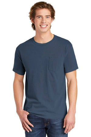 A young man with light brown hair smiles against a plain background, wearing the Comfort Colors Heavyweight Ring Spun Pocket T-Shirt 6030 in blue, paired with blue jeans.