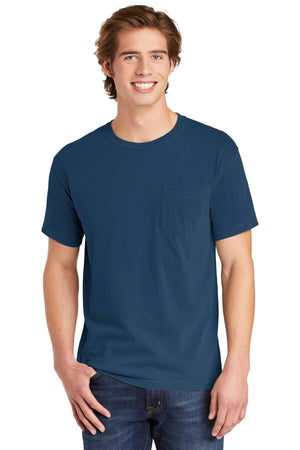 A young man is smiling with one hand in his pocket, wearing a Comfort Colors Heavyweight Ring Spun Pocket T-Shirt 6030 in blue.
