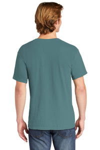 A person with light brown hair, seen from behind, is wearing a teal customized Comfort Colors Heavyweight Ring Spun Pocket T-Shirt 6030 and blue jeans.