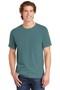 A young man stands and smiles at the camera, wearing blue jeans and a Comfort Colors Heavyweight Ring Spun Pocket T-Shirt 6030 in teal.