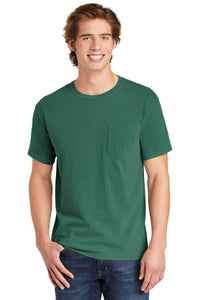 A young man, smiling at the camera, wears blue jeans and a green Comfort Colors Heavyweight Ring Spun Pocket T-Shirt 6030.