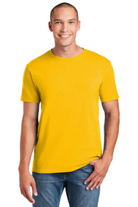 A person in a yellow Gildan Softstyle T-Shirt 64000, with a modern classic fit, smiles against a plain white background. The shirt's tearaway label enhances comfort, and its ring-spun cotton ensures softness.
