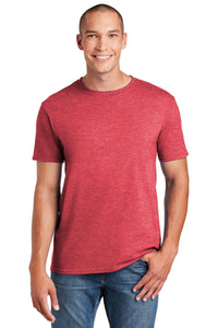 A person in a Gildan Softstyle T-Shirt 64000, crafted from smooth ring spun cotton, and jeans is smiling, standing in a neutral pose. The red tee by Gildan features a modern classic fit with a tearaway label for added comfort and style.