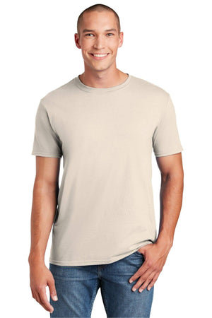 A man in a plain Gildan Softstyle T-Shirt 64000 made of ring-spun cotton and blue jeans stands smiling with a hand in his pocket against a plain white background, showcasing a modern classic fit.