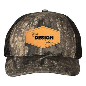 The Richardson 111P Washed Printed Snapback Trucker Hat features Mossy Oak camo mesh, a brown hexagonal patch with "Your Design Here" text, a custom embroidered front, and an adjustable snapback closure.
