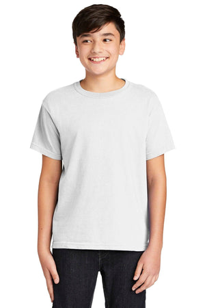 A smiling person stands wearing a Comfort Colors Youth Ring Spun T-Shirt 9018 in plain white and dark jeans against a white background.