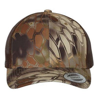 A YP Classics polyester/cotton blend trucker hat with a snapback closure and camo pattern.