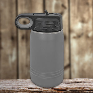 Gray Kodiak Coolers vacuum-sealed insulated water bottle with a flip-top lid on a wooden surface against a blurred wooden backdrop.