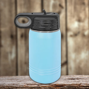 Blue Kodiak Coolers vacuum-sealed insulated stainless steel water bottle with black lid on a wooden surface against a blurred background.