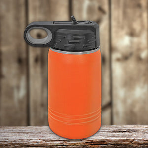 An orange insulated stainless steel water bottle with a black lid and carrying loop, featuring vacuum-sealed insulation technology, set on a wooden surface against a blurred wooden background by Kodiak Coolers Custom Kids Water Bottles 12 oz Personalized with your Logo, Design or Names - Special New Years Sale Bulk Pricing - LIMITED TIME.