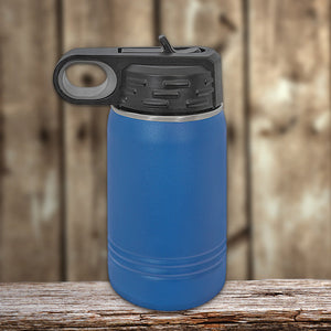 Blue vacuum-sealed insulated stainless steel water bottle with a black flip-top lid on a wooden surface against a wooden backdrop by Kodiak Coolers.