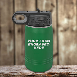 A green 12 oz Kodiak Coolers Custom Kids Water Bottle with a black lid, placed on wood, featuring "YOUR LOGO ENGRAVED HERE"—perfect for personalizing with your logo or design. Special Black Friday sale—volume pricing, limited time!.