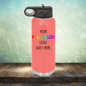 A pink insulated water bottle with a black lid is displayed on a wooden surface with a watery background. The text "Custom UV Printed Drinkware - Single Side Printing Included in Price by Kodiak Coolers" is printed on the bottle in rainbow colors, making it the perfect companion alongside personalized coffee mugs and customized tumblers.